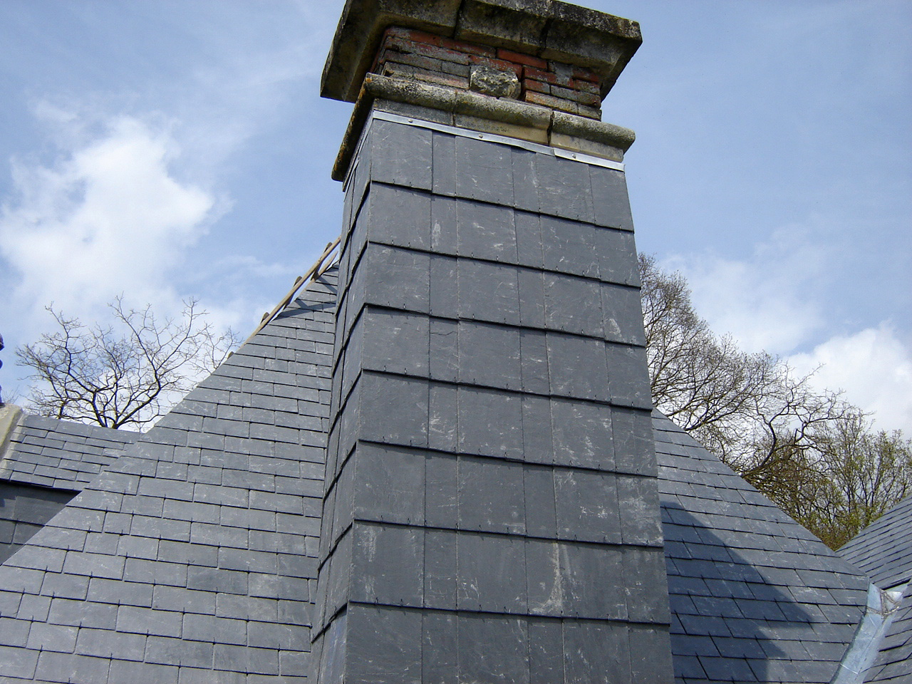 Habillage en ardoises d'une cheminée pour la protéger des intempéries.