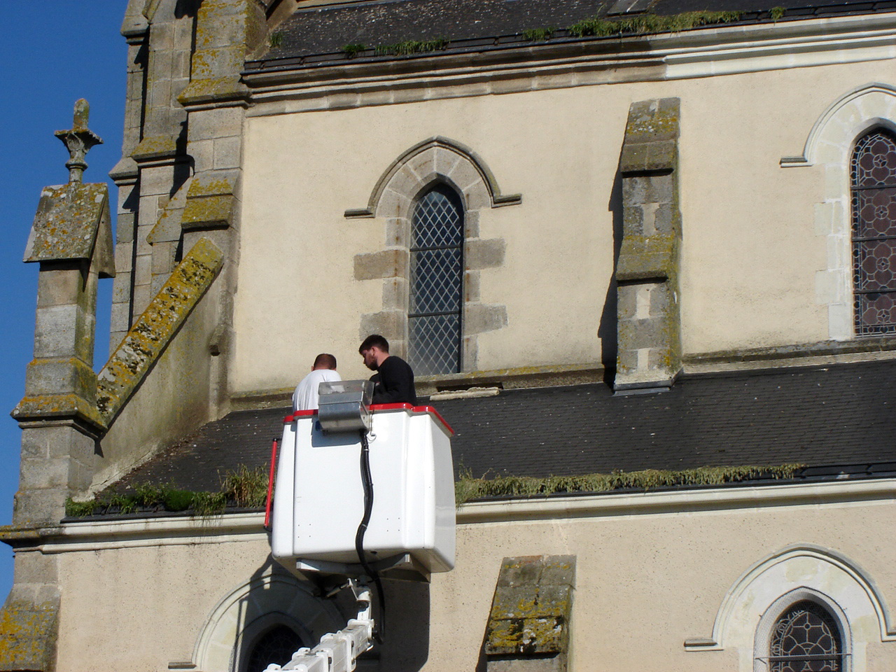 Intervention sur la toiture d'une église pour son entretien à l'aide d'une nacelle télescopique