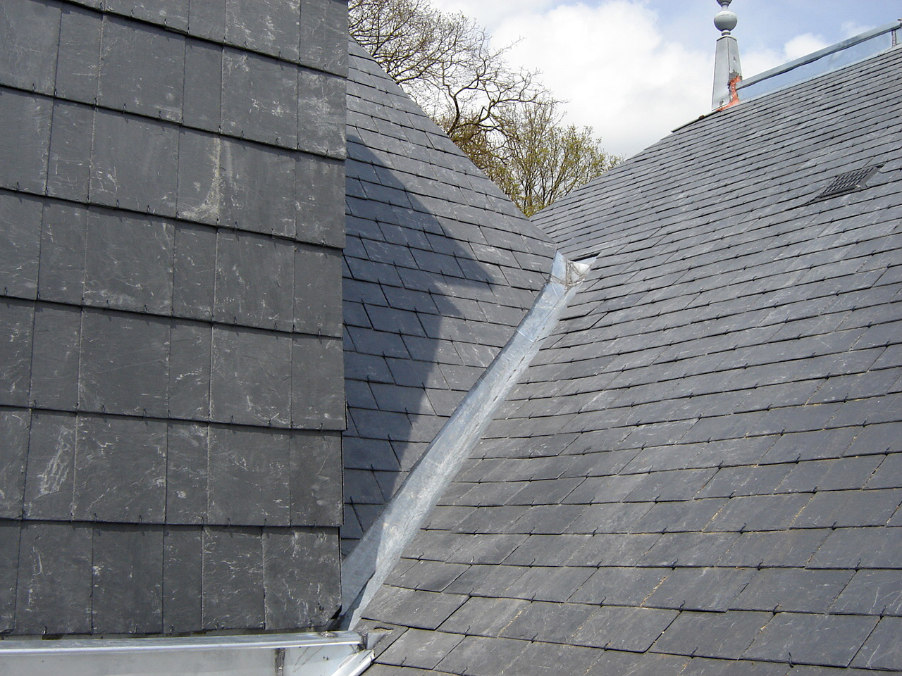 Réalisation d'une noue en zinc pour l'évacuation des eaux pluviales sur une toiture en ardoises