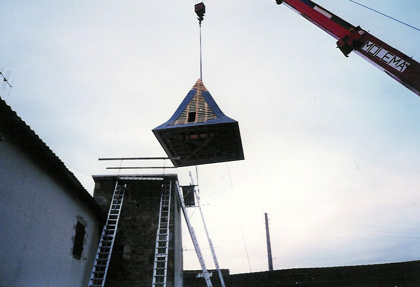 restauration patrimoine ancien tour carrée La toiture est soulevée par la grue pour retrouver sa place sur la tour